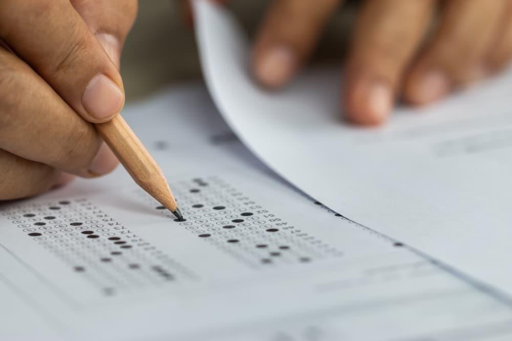 Student filling out scantron answer sheet for standardized test.