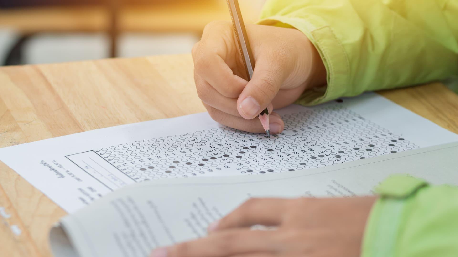 Student taking a standardized test and filling in the answer sheet.