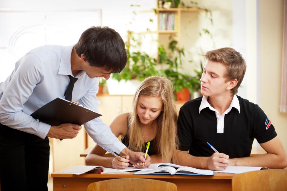 Tutor helping two high school students study for a test.