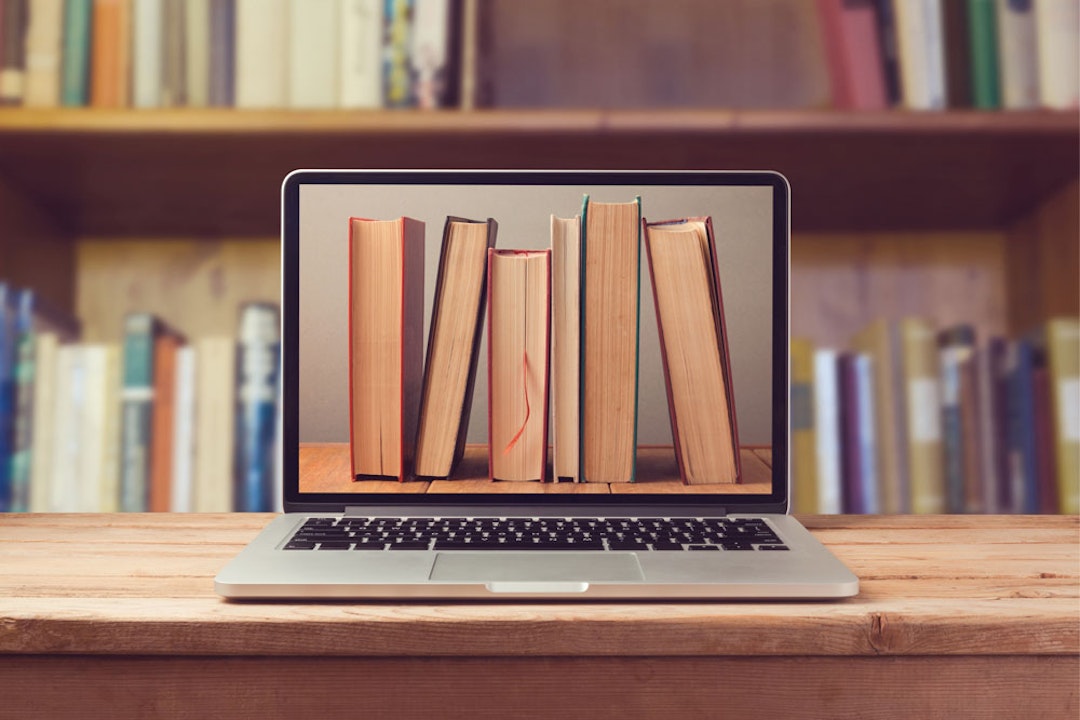 An open laptop showing six books in the screen