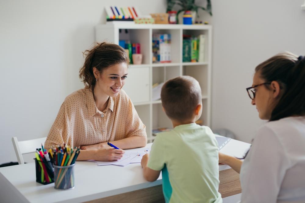 Little boy and mother talking to school psychologist.