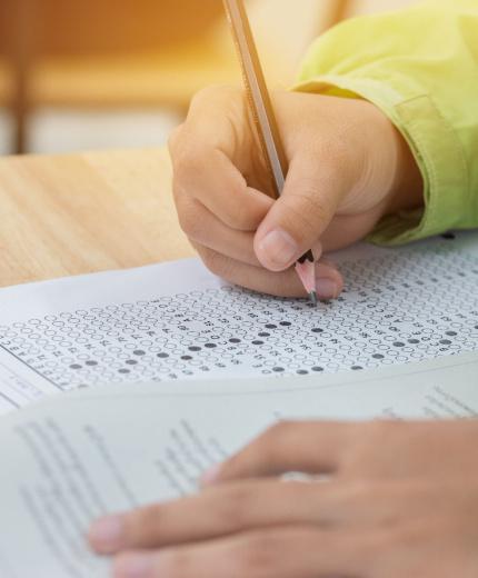 Student taking a standardized test and filling in the answer sheet.