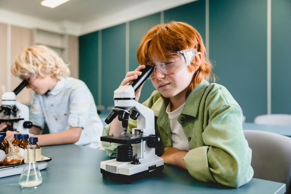 Children in classroom using laptops, tablets, and mobile devices that are connected with AI.